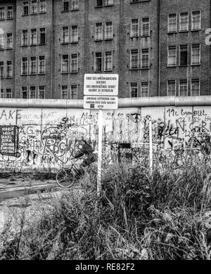 August 1986, Berlin Wall graffitis, warning sign for end of American sector, cyclist, East Berlin building, West Berlin side, Germany, Europe, Stock Photo