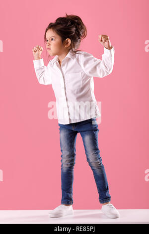 angry little child girl in white shirt with hairstyle Stock Photo