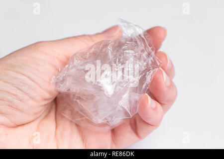 A woman holds in her hand a crumpled transparent bag. Ecology, waste recycling. Stock Photo