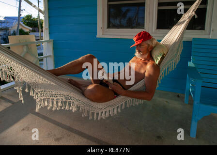 Typical loyalist house, Hope Town, Elbow Cay, Abacos. Bahamas. Relaxing in a hammock. Stock Photo