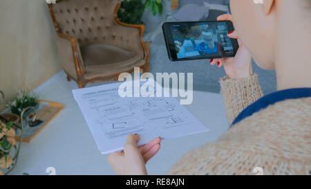 MOSCOW, RUSSIA - AUGUST 10, 2018. Woman using smartphone with augmented reality app - virtual robotized production module. Future, production, industrial and technology concept Stock Photo