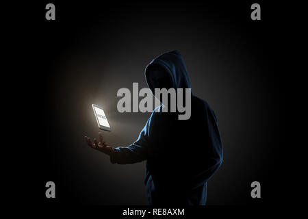 White smartphone with text "HACKER" on screen floating above of hacker's hand in dark background. Finance, business, e-commerce or cyber crime concept Stock Photo