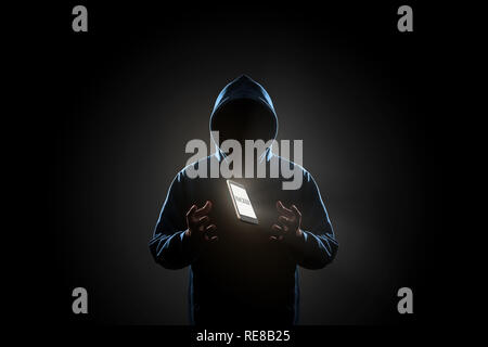 White smartphone with text "HACKER" on screen floating above of hacker's hand in dark background. Finance, business, e-commerce or cyber crime concept Stock Photo