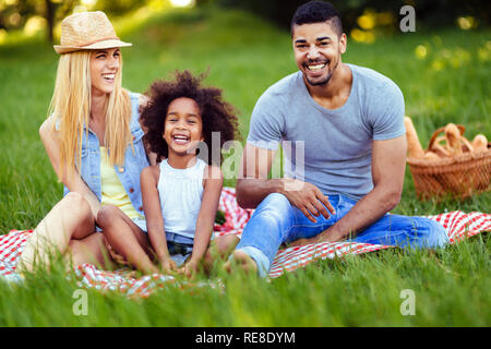 Picture of lovely couple with their daughter having picnic Stock Photo
