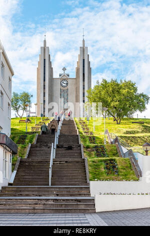 Akureyri, Iceland - June 17, 2018: Street in town village city with people on steps to famous church on hill and vertical view Stock Photo