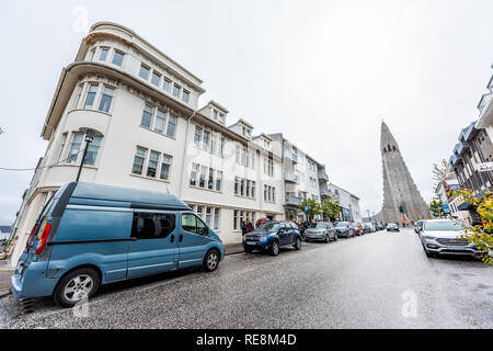 Reykjavik, Iceland - June 19, 2018: Wet street road and parked cars in downtown center and famous Hallgrimskirkja church Stock Photo