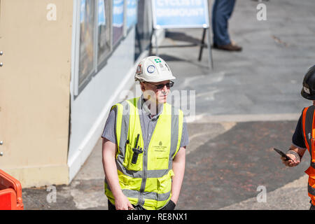 London, UK - June 22, 2018: High angle view on one construction worker, man with neon yellow green uniform vest clothing with helmet on city street Stock Photo