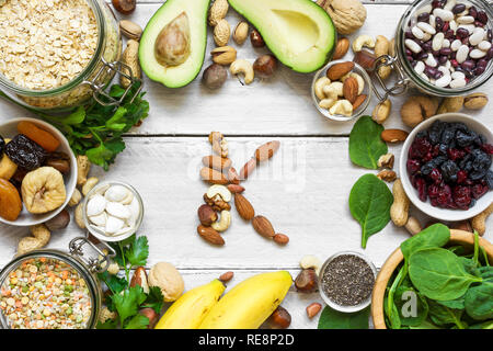 Potassium Food Sources as dried apricots, avocado, bean, pumpkin and chia seeds, banana, nuts, spinach. top view. flat lay Stock Photo
