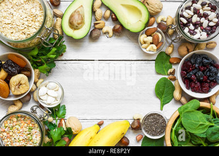 Potassium Food Sources as dried apricots, raisins, avocado, bean, pumpkin and chia seeds, banana, nuts, spinach, almonds. top view with copy space. fl Stock Photo