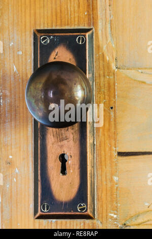 Close-up of antique style doorknob on wooden door of a bedroom inside an old 1807 Canadiana style fieldstone home Stock Photo
