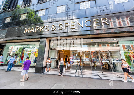 London, UK - June 24, 2018: Marks & Spencer store shop with people walking exiting on sidewalk in Soho with large sign exterior entrance Stock Photo