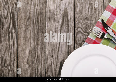 Tablecloth and cutlery on the right side on a wooden table and copy space. Food background Stock Photo