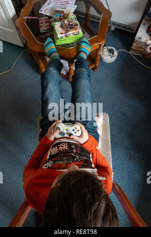 Looking down at an XBOX 360 controller in a boy's hands. Stock Photo