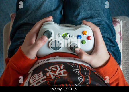 Looking down at an XBOX 360 controller in a boy's hands. Stock Photo