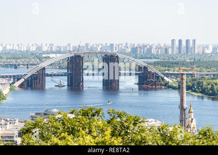 View of Kyiv town cityscape skyline with Soviet buildings in Kiev city residential suburbs neighborhood with Dnieper Dnepr river and old abandoned bri Stock Photo