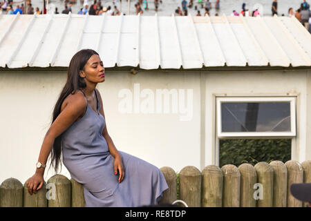 Durban, South Africa - January 06th, 2019: Portrait of a South African woman sitting relaxed at the beach in Durban, South Africa. Stock Photo