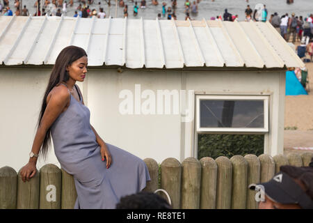 Durban, South Africa - January 06th, 2019: Portrait of a South African woman sitting relaxed at the beach in Durban, South Africa. Stock Photo