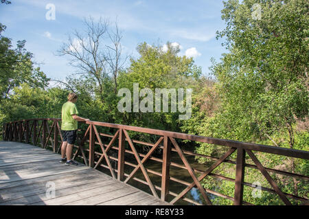 Naperville, Illinois, United States-September 4,2017:  One person on footbridge at McDowell Grove Forest Preserve in Naperville, Illinois Stock Photo