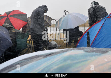 Plane spotters at an airshow suffering heavy rain bad weather. Extreme storm. British weather. Windy. Squally. People in waterproofs Stock Photo