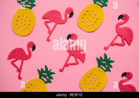 Tropical background in minimal style. Lots of pineapples and flamingos on a pink background. Stock Photo