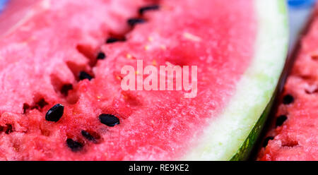 Watermelon fresh sliced of red with magnified macro shot and close up shot on wood table. Background.