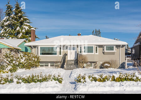 Average residential house in snow on sunny winter day Stock Photo