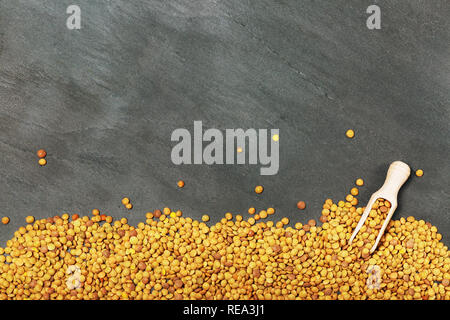 Raw lentils on balck stone background. Healthy vegetarian food concept. Superfoods. Top view, copy space. Lentils are rich in complex carbohydrates, f Stock Photo