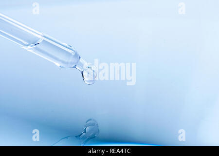 waterdrop with little waves from a pipette Stock Photo