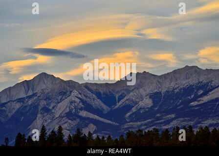 A horizontal image of Lenticular clouds in the sky over a rocky mountain range in Jasper National Park in Alberta Canada. Stock Photo
