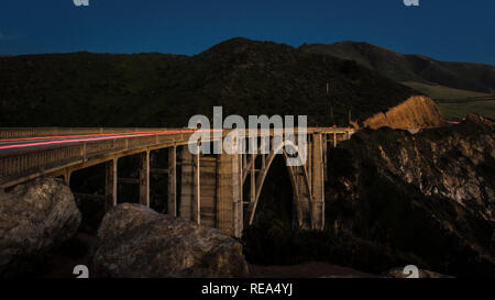 Cars cross the Bixby Creek Bridge at dusk in Big Sur, California. Stock Photo