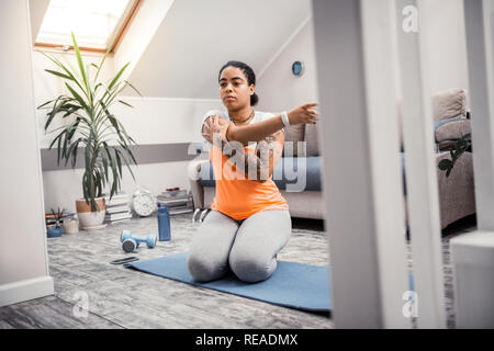 African American concentrated woman stretching her hands