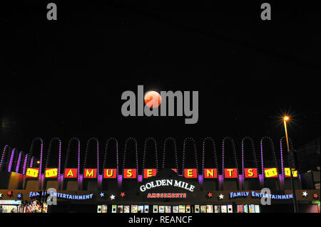 Blackpool,UK. 21st January 2019. A total lunar eclipse super blood wolf moon shining over the Golden Mile amusement centre on the promenade at Blackpool and lasting for three hours and 17 minutes. Kev Walsh/ Alamy Live News Stock Photo