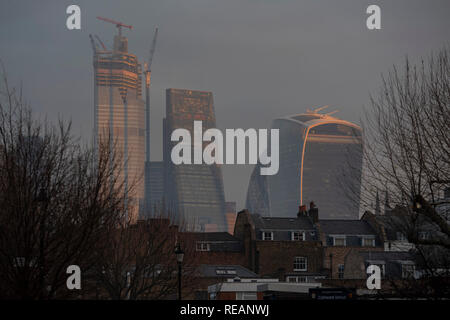 London, UK. 21st January, 2019. The rising sun shines on the tower blocks of the City of London. Credit: Guy Bell/Alamy Live News Stock Photo