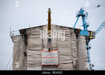 Bremerhaven, Germany. 21st Jan, 2019. The bowsprit of the sail training ship of the German Navy which is under repair, the 'Gorch Fock', looks out in the dock under the tarpaulins. Defence Minister von der Leyen wants to decide within a few weeks on the future of the ailing sailing training ship 'Gorch Fock'. Credit: Mohssen Assanimoghaddam/dpa/Alamy Live News Stock Photo