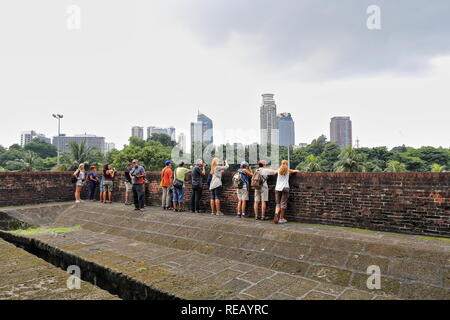 Manila, Philippines-October 24, 2016: Tourists admire the urban skyline as seen from the rooftop of the Ravelin of Royal Gate off the curtain wall of  Stock Photo