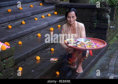 Lady making traditional Balinese offering to the gods, Ubud, Bali, Indonesia. Stock Photo