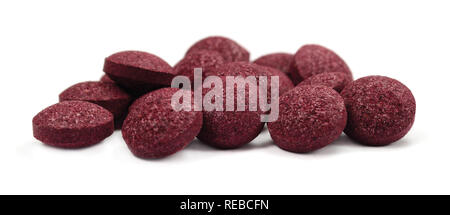 Black chokeberry fruit pills, large detailed isolated tablets macro closeup, organic raw aronia melanocarpa berry fruits pill pile, burgundy colored Stock Photo