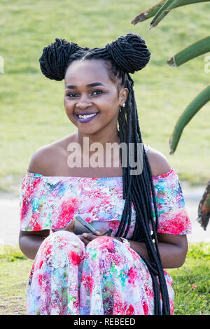 Durban, South Africa - January 06th, 2019: Portrait of a black south african woman with dreadlocks and tooth grillz in Durban, South Africa. Stock Photo