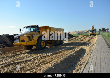 RYNARZEWO, KUJAWSKO-POMORSKIE/POLAND - MAY 25, 2018 - S5 construction site - empty yellow Volvo hauler, excavator and workers, sidewalk Stock Photo