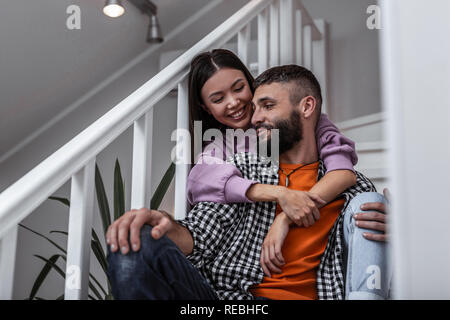 Woman smiling broadly while spending day at home with husband Stock Photo