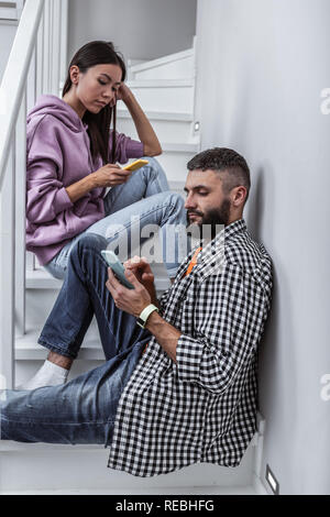 Couple addicted to social media using their smartphone Stock Photo