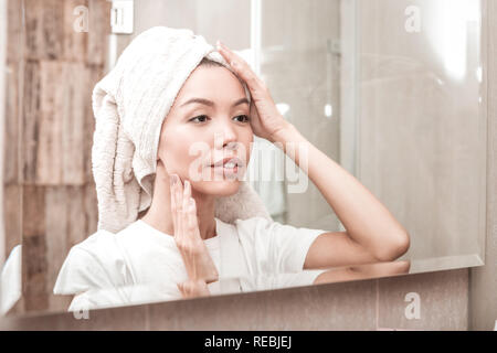 Nice young woman looking at her reflection Stock Photo