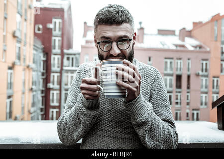 Nice good looking man enjoying his warm drink Stock Photo