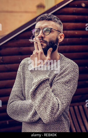 Nice thoughtful man holding a cigarette in his hand Stock Photo