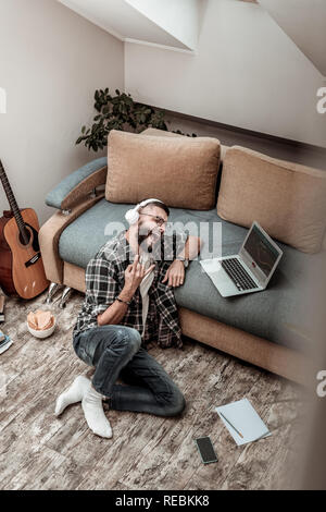 Positive cheerful young man singing a song Stock Photo