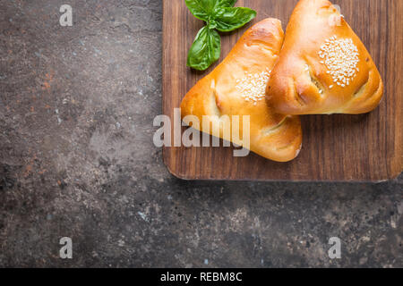 Homemade chicken and mushroom mini pies on cutting board, top view Stock Photo
