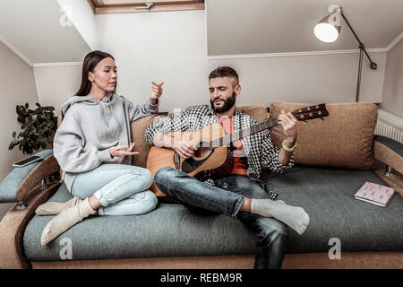 Nice young couple sitting together on the sofa Stock Photo