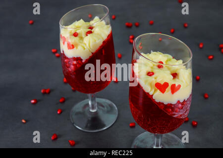 Dessert panakota and red jelly and pomegranate seeds on rustic wooden table Stock Photo