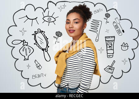 Young woman studio standing isolated in white wall looking camera smiling proudly Stock Photo