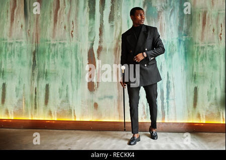 Stylish african american gentleman in elegant black jacket, holding